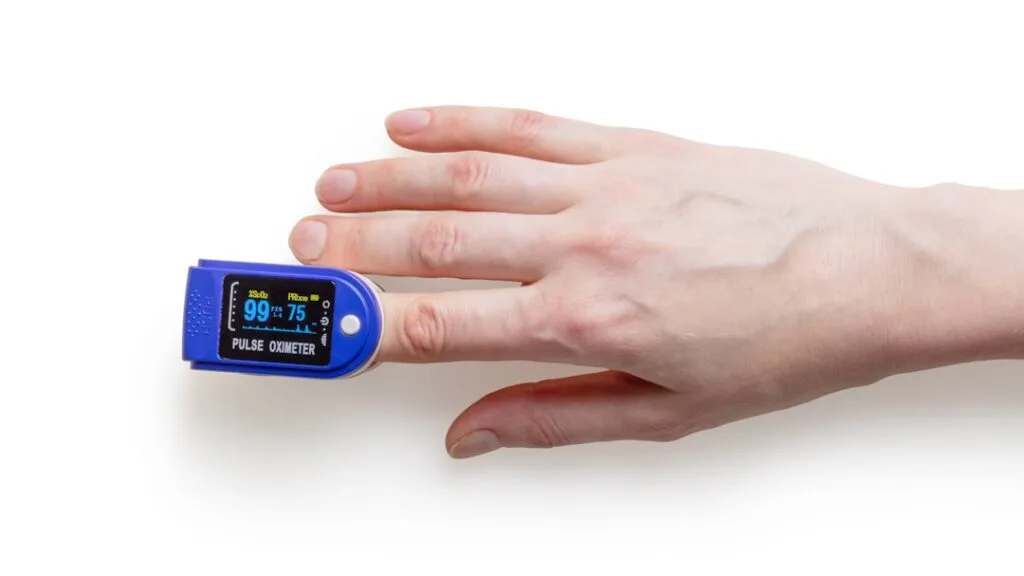 Clean medical oximeter with hand on white background